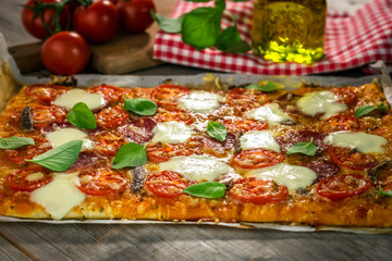 Homemade Italian pizza with mozzarella, tomato and basil leaves