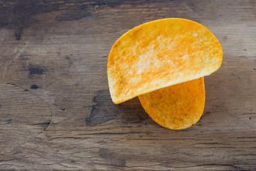 Potato chips on dark wooden background / snack potatoes.