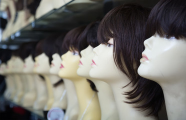 female mannequins with wigs on shelves of hair salon
