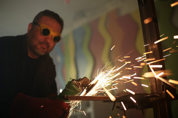 Worker grinding iron metal