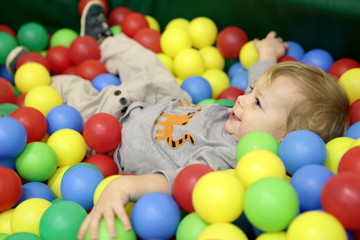 Fototapeta na wymiar Toddler playing in box of balls