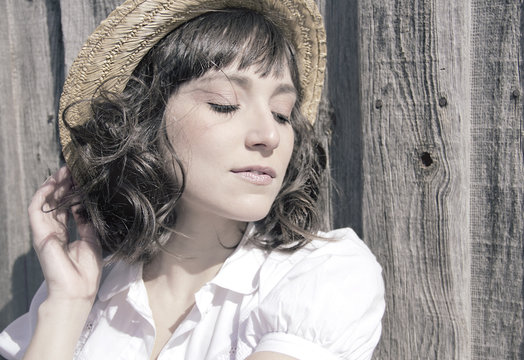 Retrato vintage de una chica de campo con camisa blanca y sombrero de paja 