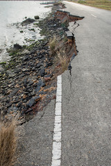 Side of the broken asphalt road collapsed and fallen