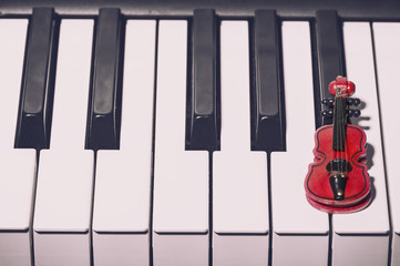 Music concept. Red decorative violin on the piano