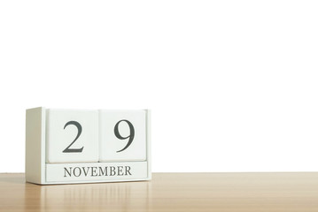 Closeup surface white wooden calendar with black 29 november word on blurred brown wood desk isolated on white background with copy space , selective focus at the calendar