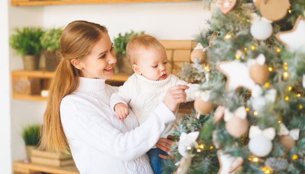 family mother and baby decorate Christmas tree