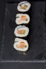 Pieces of sushi on a black stone