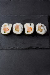 Pieces of sushi on a black stone