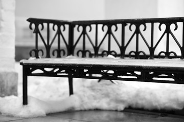 Vintage metal bench in snow bokeh backdrop