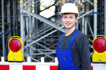 junger Mann in Arbeitskleidung auf der Baustelle