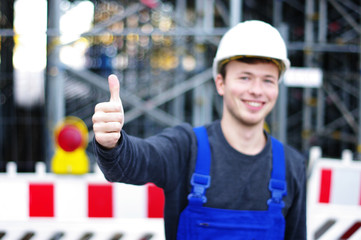junger Mann in Arbeitskleidung auf der Baustelle