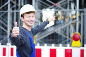 junger Mann in Arbeitskleidung auf der Baustelle