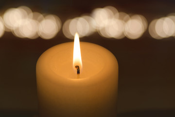 Kerze brennt mit Bokeh im Hintergrund