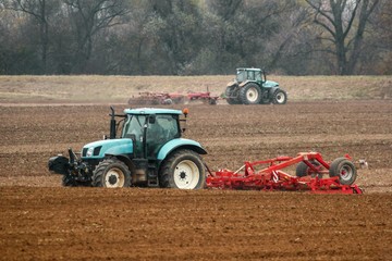 Tractors cultivating soil