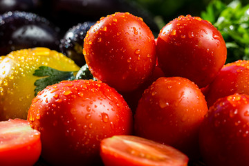 Close-up of fresh, ripe tomatoesand eggplant.Group of tomatoes and eggplant. Red and yellow tomatoes, tomatoes and eggplant in drops of water 