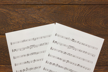 Top view Christmas music note paper on wooden table background.C