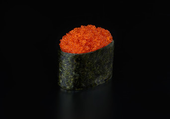 Flying fish tobiko roll gunkan isolated on black background © GoSlow