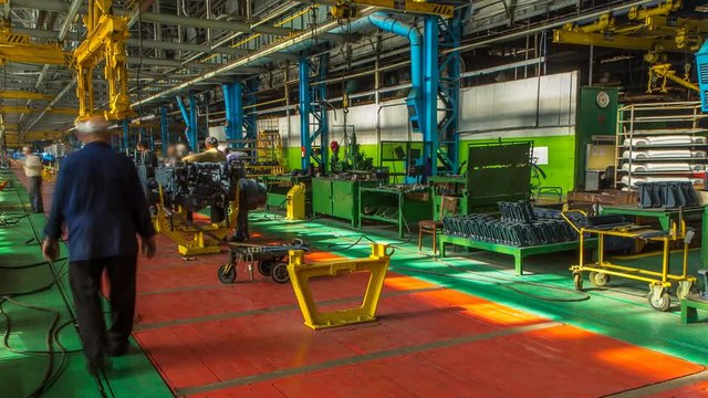 Conveyor assembly stage the body of tractor at factory timelapse