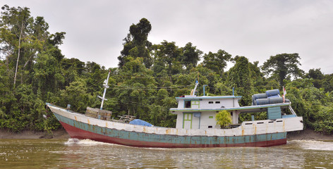 Indonesian traditional merchant ship on the river. New Guinea Island.