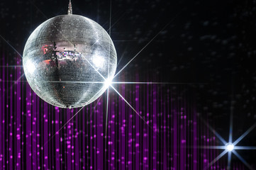 Party disco ball with stars in nightclub with striped violet and black walls lit by spotlight,...