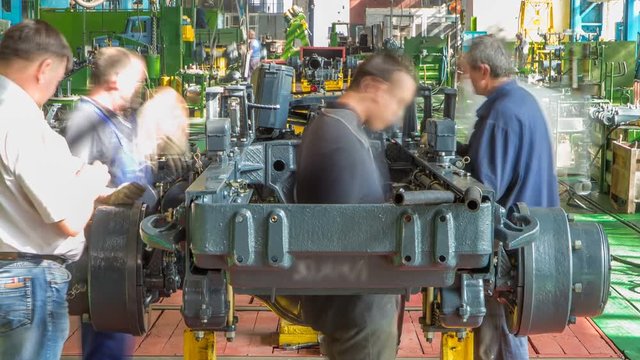 Conveyor assembly stage the body of tractor at factory timelapse