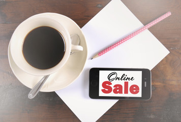Online Sale message on phone device with cup of coffee