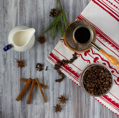Coffee in turk, milk, coffee beans, spice on the table