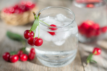 Cold water with ice and cherries. Selective focus.
