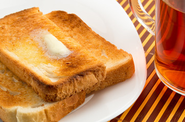 Hot toast with butter on a white plate