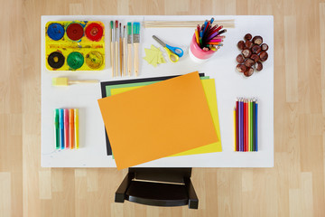 Artistic tools on white small table with small chair for children.