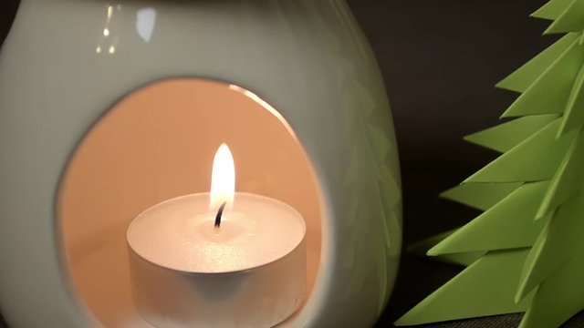 Burning candle in aroma lamp