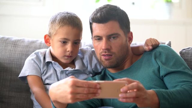 Daddy with son playing with smartphone