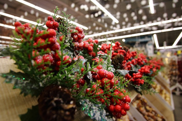 Fototapeta na wymiar Christmas souvenir artificial snow on the pine tree branches and red berry 