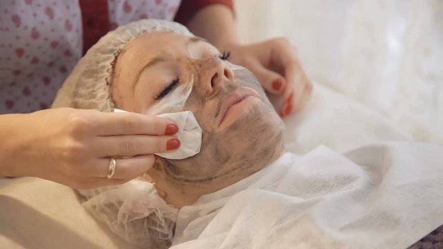 Taking off marine mug mask from female face