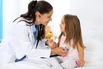 Doctor examining a little girl by stethoscope
