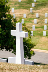 Cross and tombstones on a grassy hill at Arlington National Cemetery