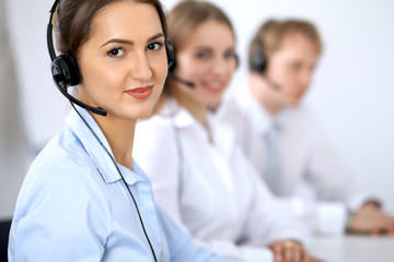 Call center. Focus on beautiful woman in headset