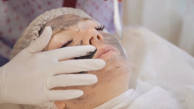 Applying marine mug mask on female face