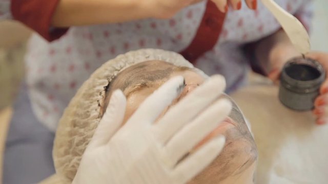 Applying marine mug mask on female face