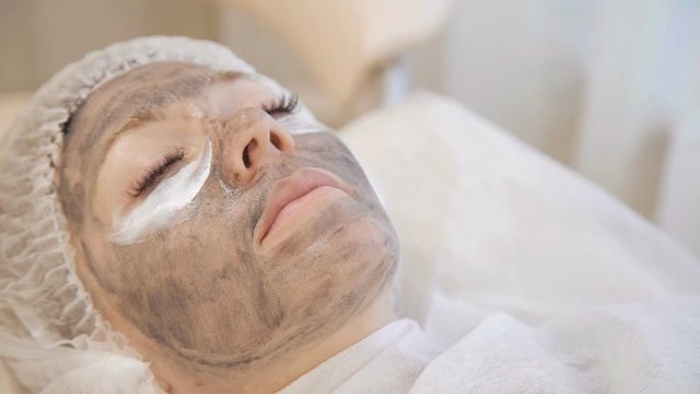 Applying marine mug mask on female face
