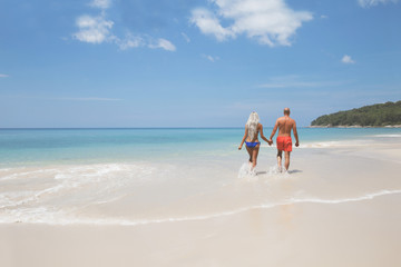 Pretty couple walking on a tropic beach