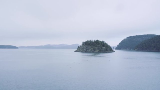 Sailing past a tiny island in the San Juan Islands, Washington, USA.