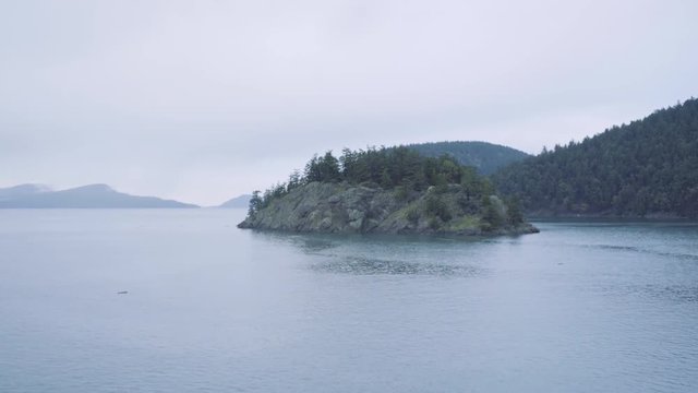 Sailing past a tiny island in the San Juan Islands, Washington, USA.