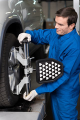 Professional mechanic adjusting automobile wheel system