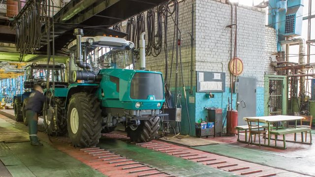 Conveyor assembly stage the body of tractor at factory timelapse
