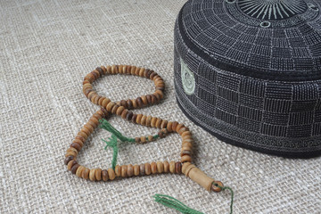 Rosary, quran isolated on wooden table.