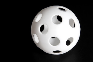 Cheap Whiffle Ball-type knock-off plastic ball with holes. Horizontal. 