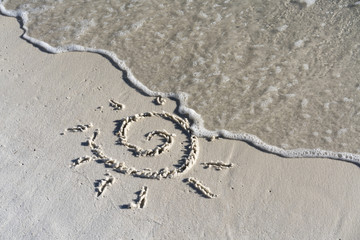 sun symbol drawn in the sand