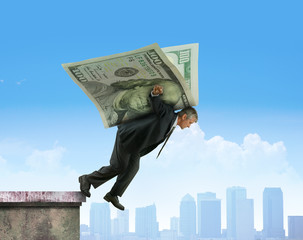 Stockbroker investor leaping off building soaring on wings of money representing financial risk, stock exchange success, successful investments, retirement savings, and many other financial concepts.