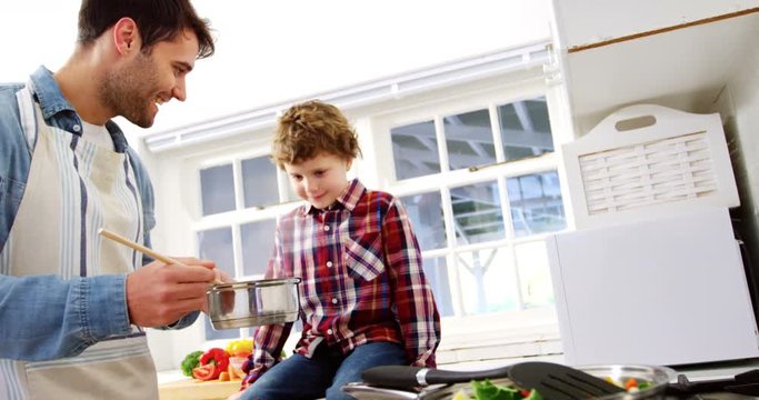 Boy looking while father cooking food
